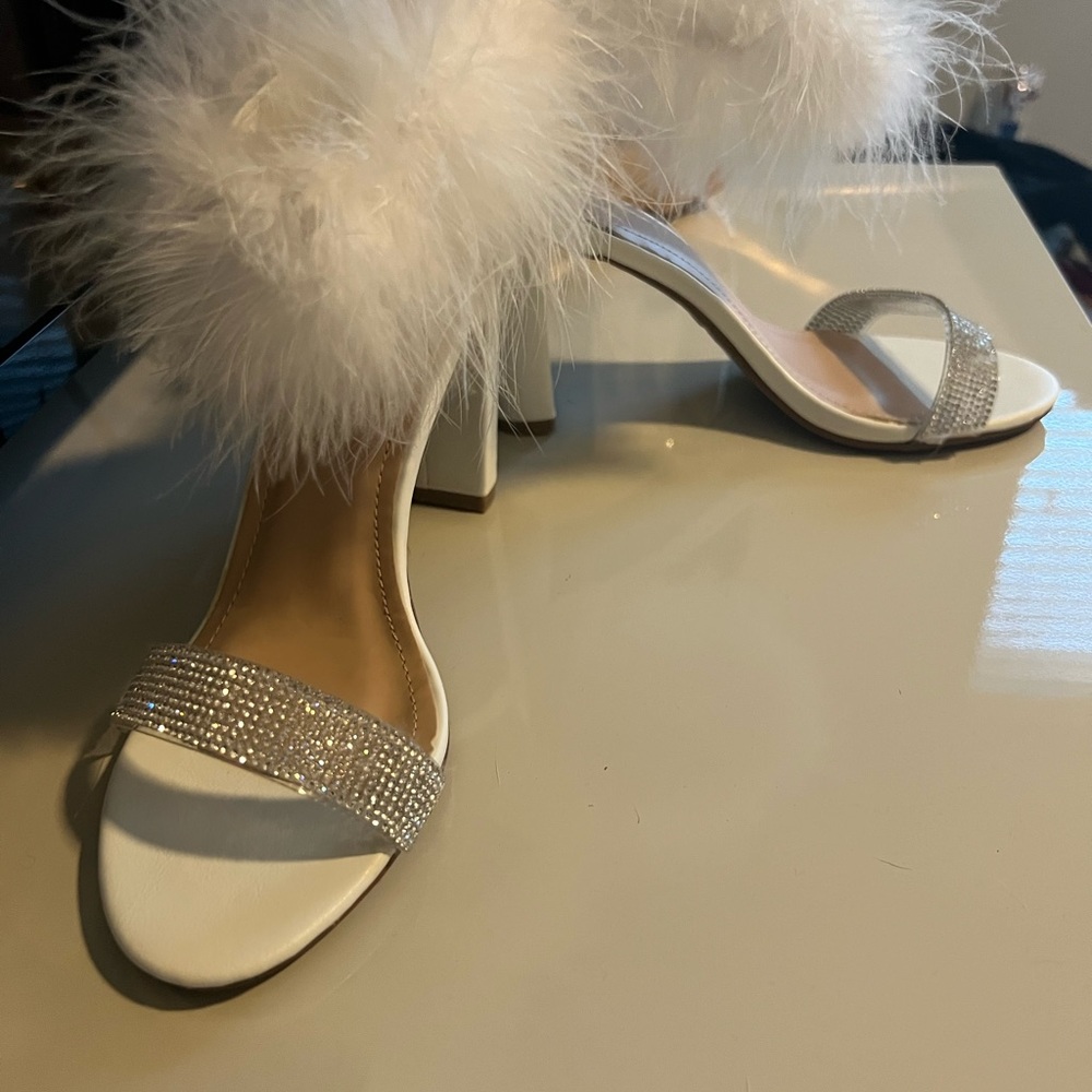 White sparkly heels with feather ankle straps.